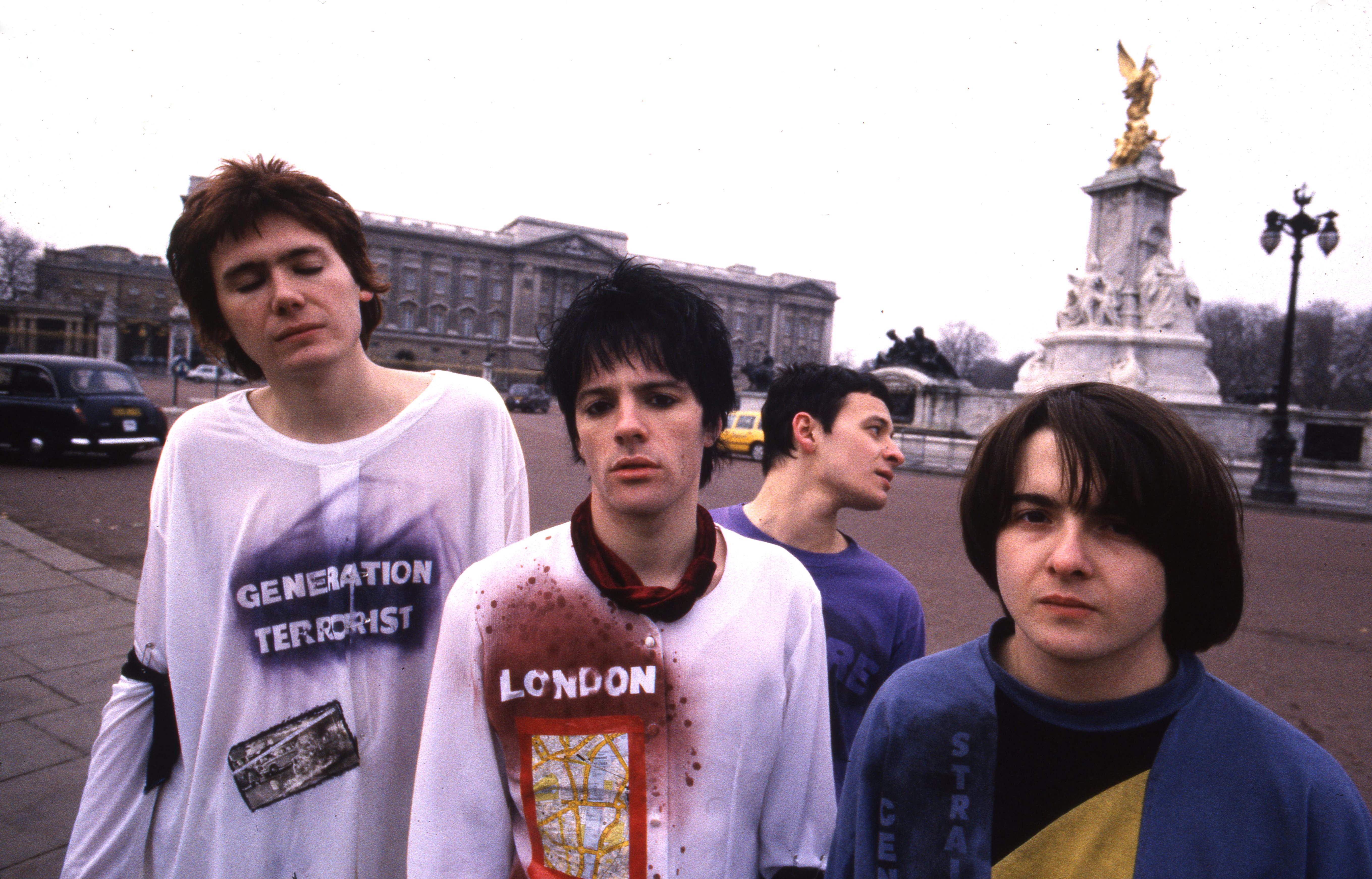 Group portrait of the Manic Street Preachers outside Buckingham Palace, London, January 1991. L-R Nicky Wire, Richey Edwards, James Dean Bradfield and Sean Moore. (Photo by Martyn Goodacre/Getty Images)