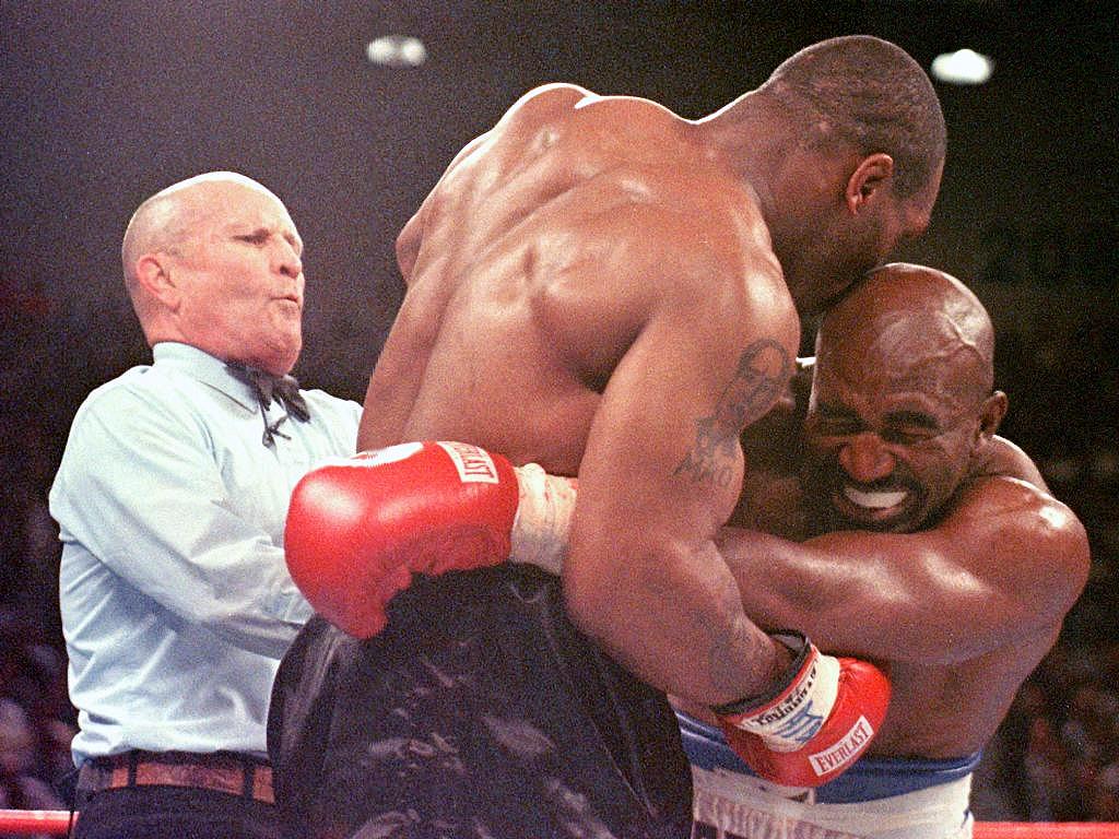 Referee Lane Mills (L) steps in as Evander Holyfield (R) reacts after Mike Tyson bit his ear in the third round of their WBA heavyweight championship fight at the MGM Grand Garden Arena in Las Vegas, NV 28 June. Holyfield won by disqualification after the biting incident.     AFP PHOTO/JEFF HAYNES (Photo by JEFF HAYNES / AFP) (Photo by JEFF HAYNES/AFP via Getty Images)