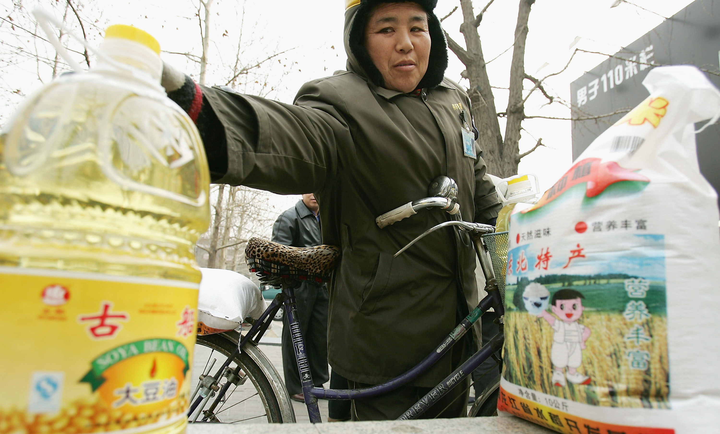 BEIJING, CHINA - FEBRUARY 5: A woman picks up a barrel of cooking oil on February 5, 2005 in Beijing, China. A local company offer rice and cooking oil for their staffs as a benefit to mark the Chinese New Year which falls on February 9. (Photo by Guang Niu/Getty Images)