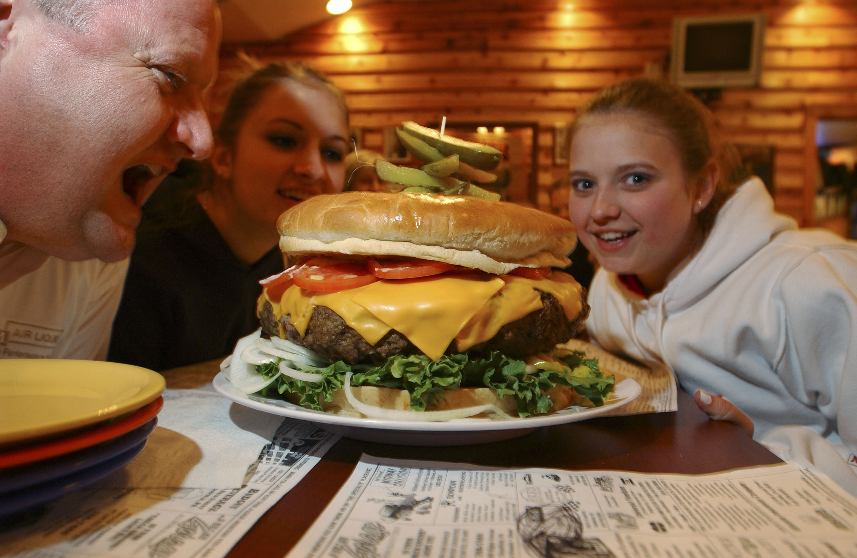 CLEARFIELD, PA - MAY 5:  Rachel Fleagle (R) her sister, Jessica and Scott Staub, all of Philadelphia pose with the burger May 5, 2005 at Denny