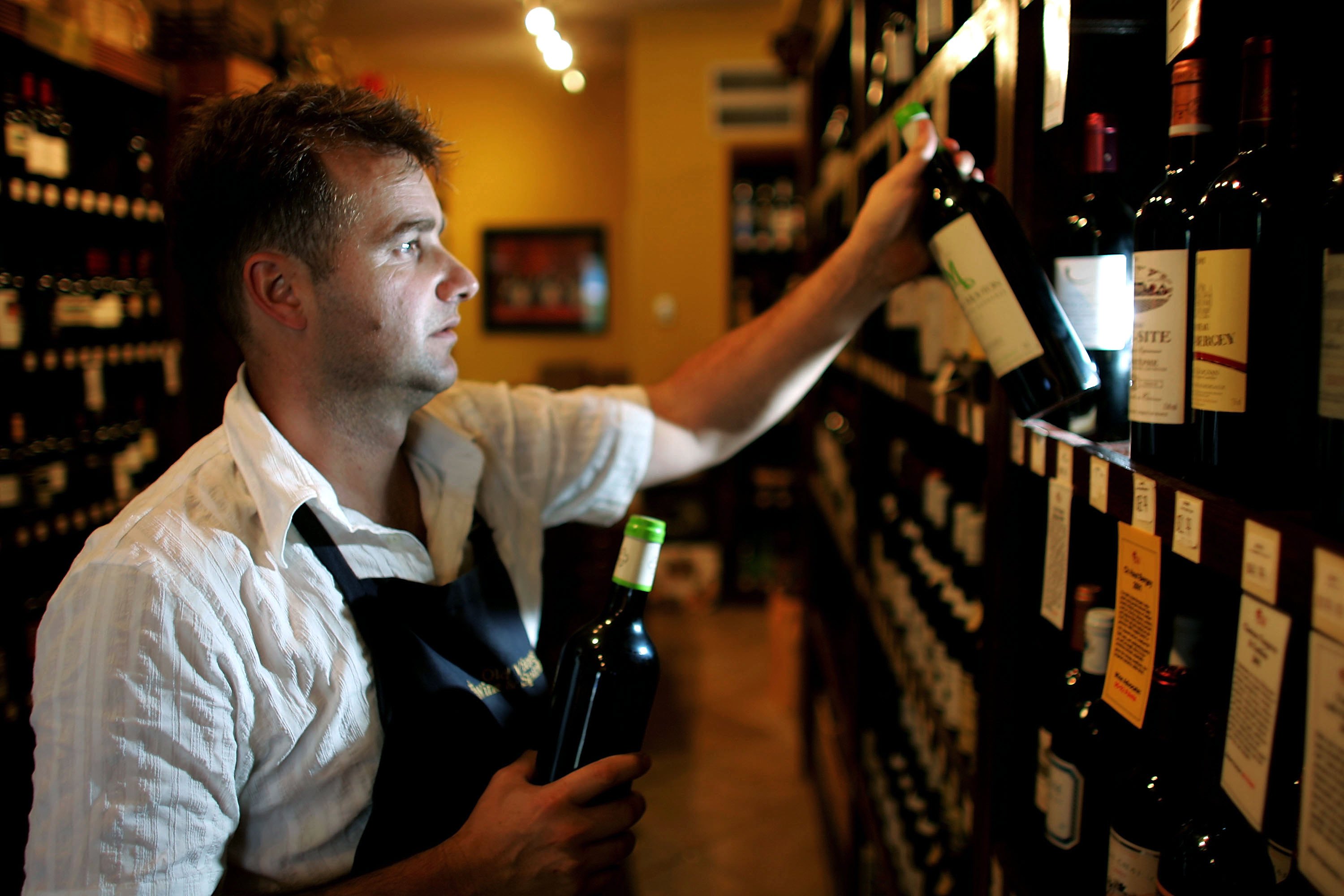 MIAMI - NOVEMBER 01:  Alex Andavert stocks the shelves with bottles of red wine at Old Vines Wine & Spirits on November 1, 2006 in Miami, Florida. A study by the Harvard Medical School and the National Institute on Aging showed that obese mice benifited from consuming huge doses of the red wine extract, resveratrol, and had a healthy effect on the fat-related ill effects.  Resveratrol is found in the skin of grapes used to make red wine.  (Photo by Joe Raedle/Getty Images)