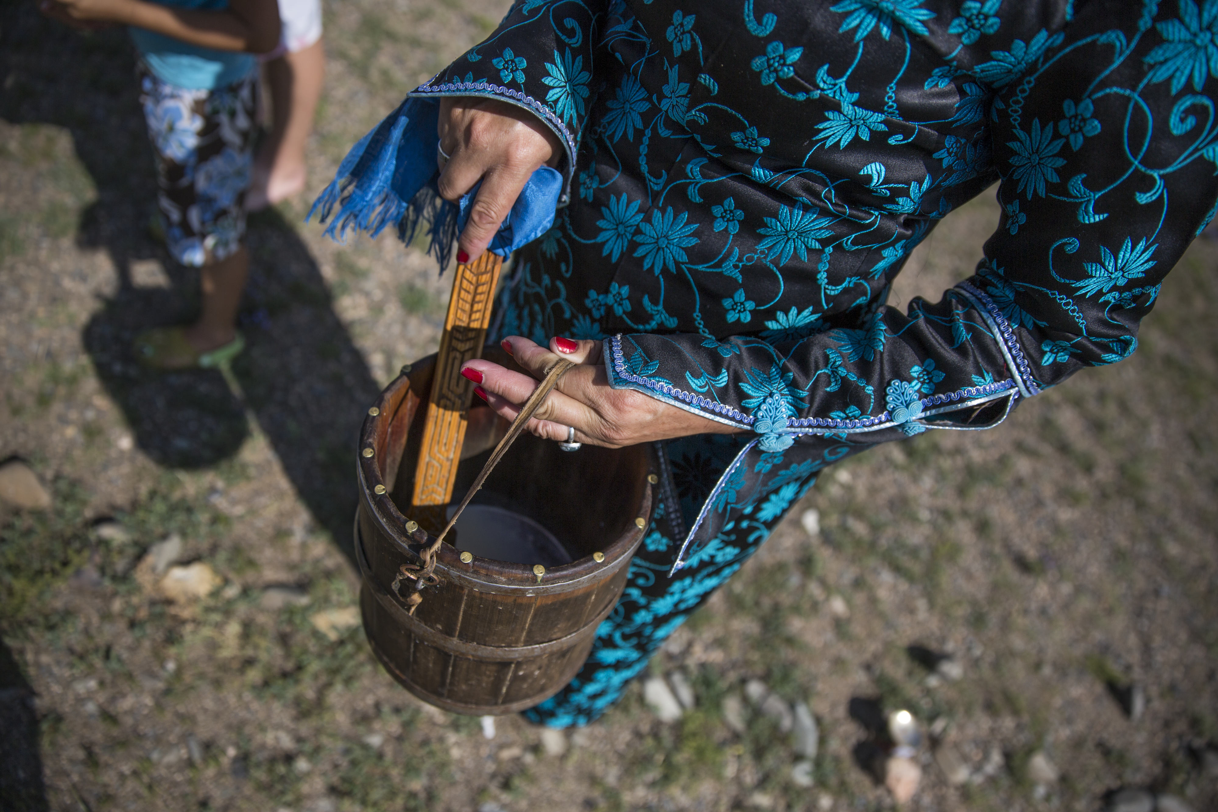 ALTANBULAG, MONGOLIA - 2016/07/29: A Mongolian woman prepares to sprinkle mare