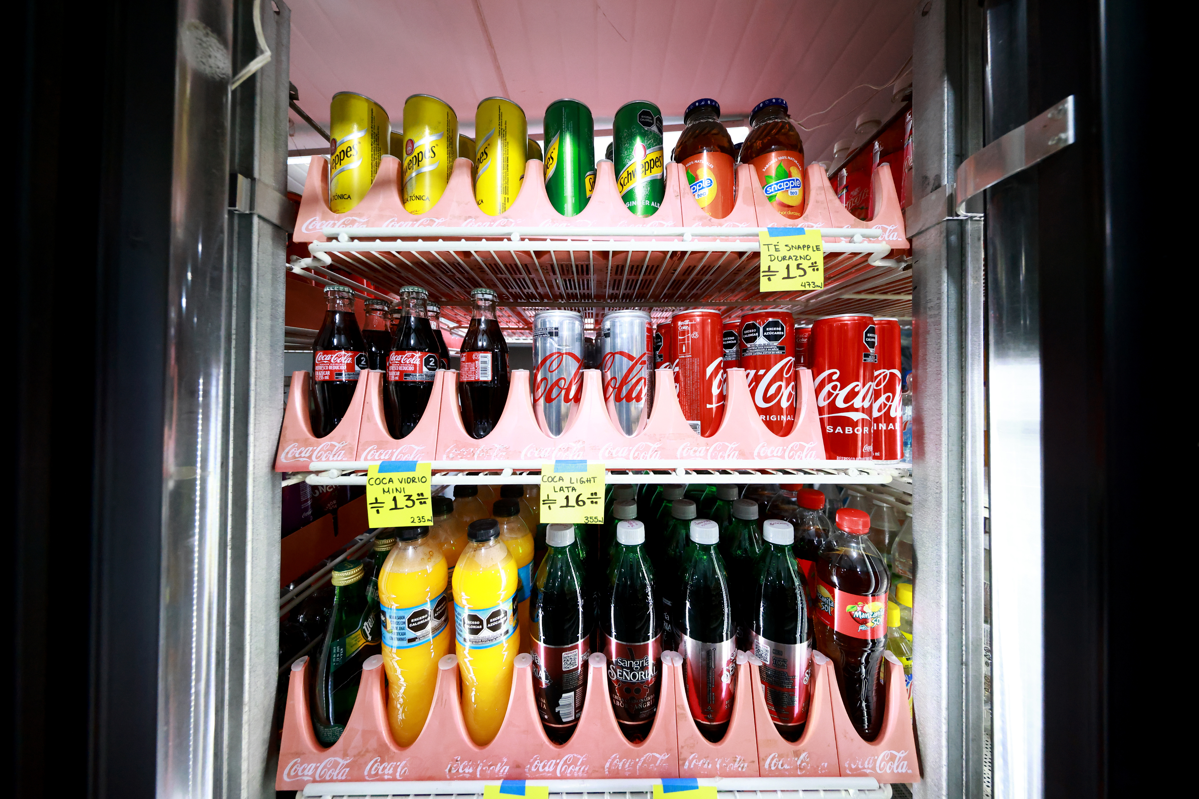 MEXICO CITY, MEXICO - JUNE 03: Different soft drinks including Coca Cola are displayed inside a refrigerator in a store on June 03, 2022 in Mexico City, Mexico. Multinational beverage and retail company FEMSA announced the increase in prices from Monday 5 due to rising inflation and higher production costs. Mexico is one of the world top consumers of Soft drinks. (Photo by Hector Vivas/Getty Images)