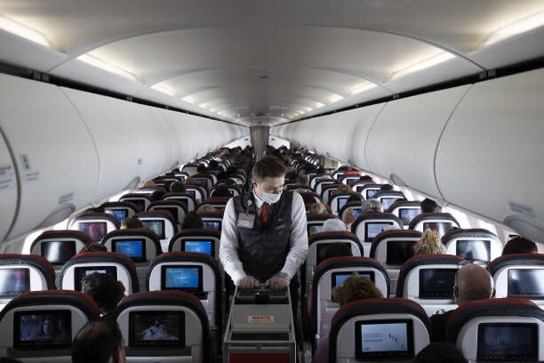ANKARA, TURKIYE - MAY 26: Ali Haydar Sancaktar, who has been a flight attendant for 2.5 years, is seen serving food and drinks during the flight ahead of the May 31, World Cabin Attendants Day in Ankara, Turkiye on May 26, 2022. (Photo by Mehmet Ali Ozcan/Anadolu Agency via Getty Images)