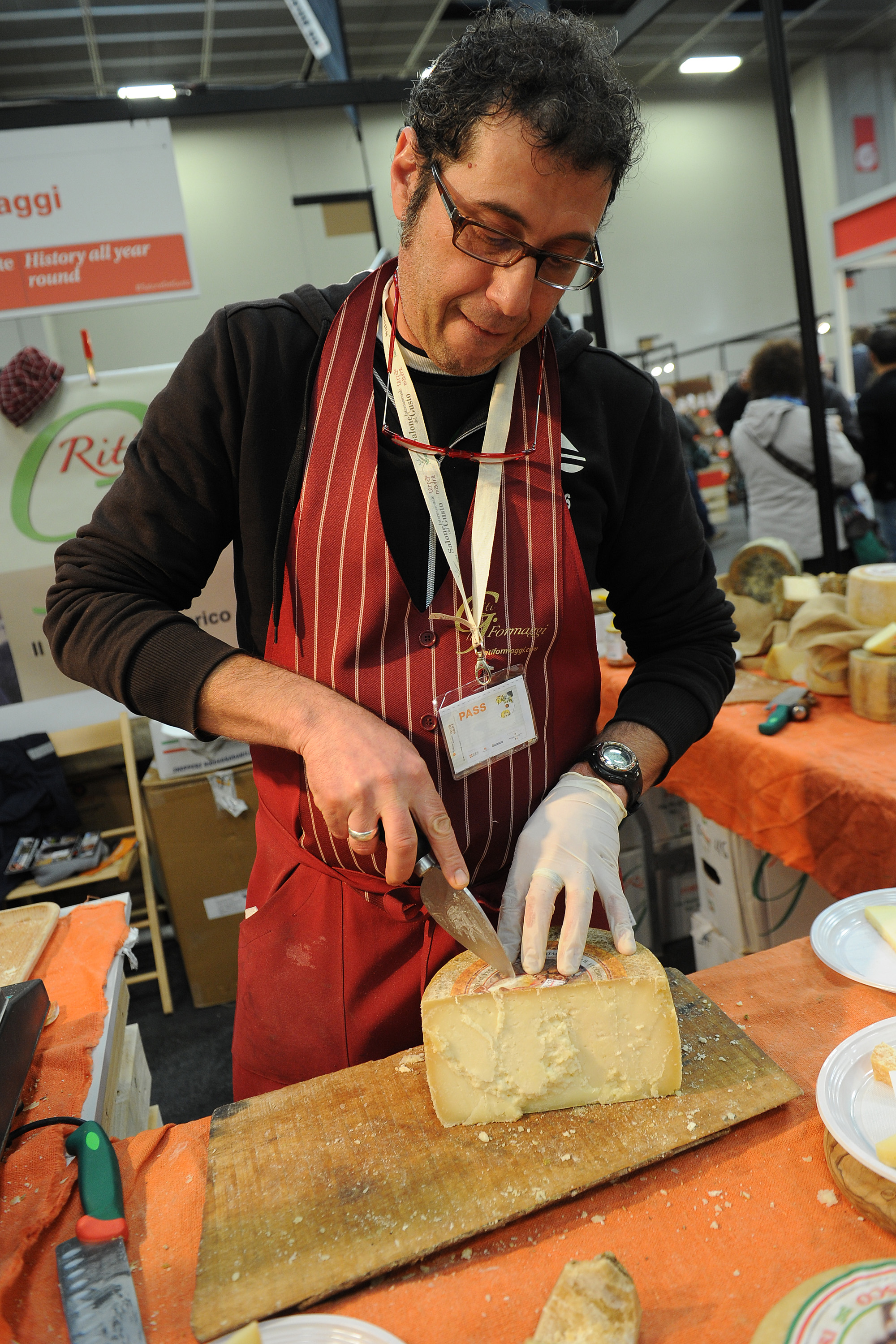 TURIN, ITALY - OCTOBER 29:  A man cuts a piece of pecorino cheese during the Slow Food