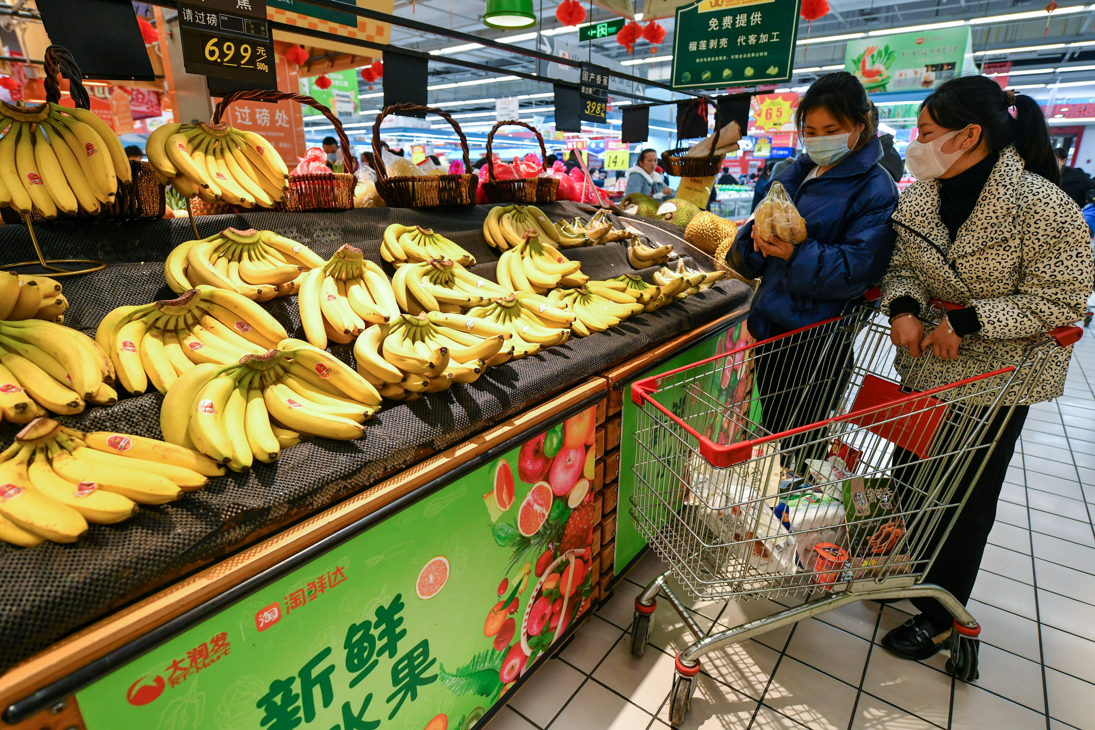 FUYANG, ANHUI, CHINA - 2022/02/15: Two shoppers seen shopping for bananas  at a Rt-Mart supermarket.
China