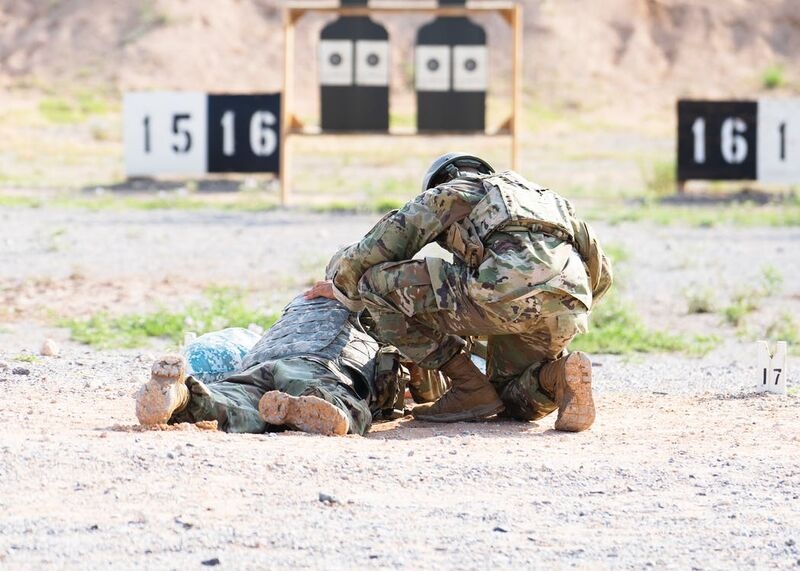 Man in Green and Brown Camouflage Uniform Sitting on Brown Rock