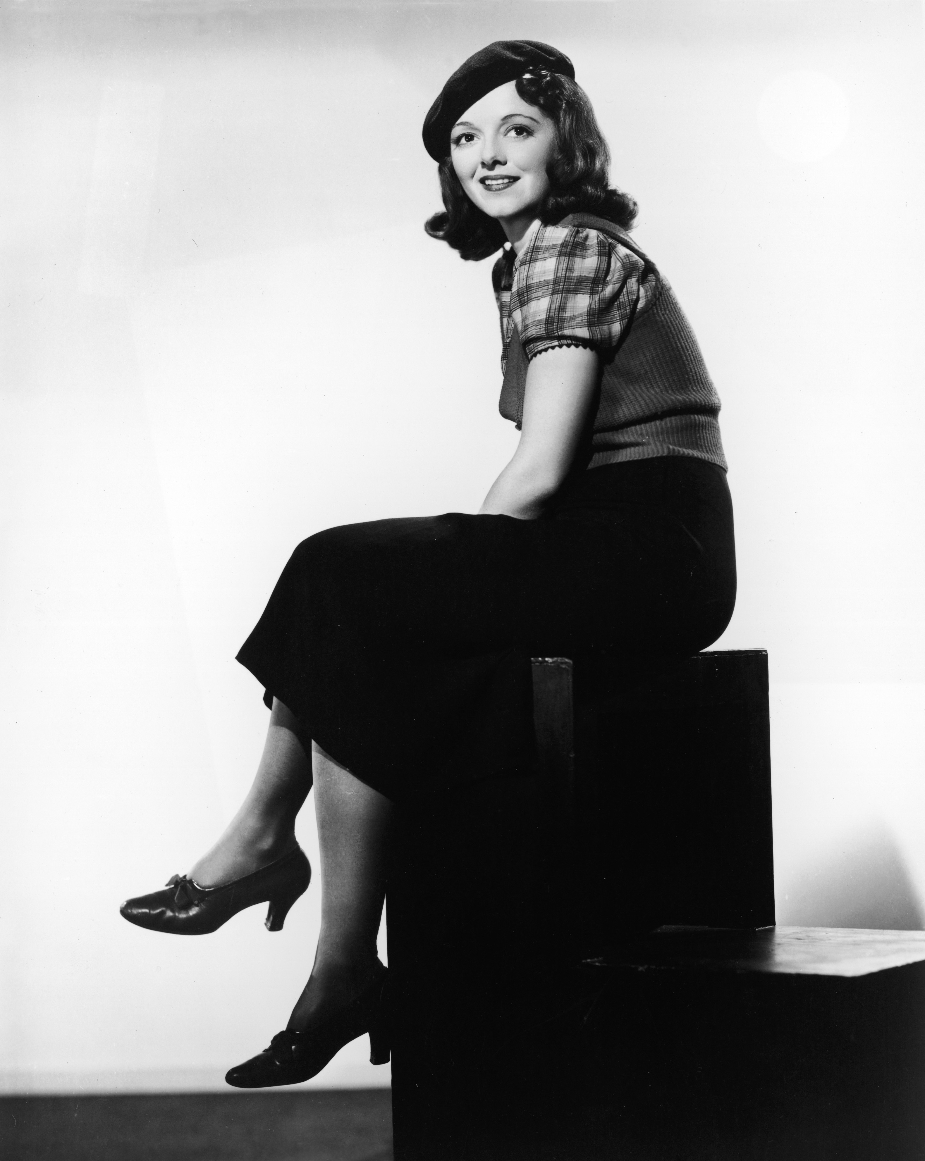 Full-length portrait of American actor Janet Gaynor (1906-1984) wearing a beret and sweater vest and sitting on a cube, circa 1940. (Photo by Hulton Archive/Getty Images)