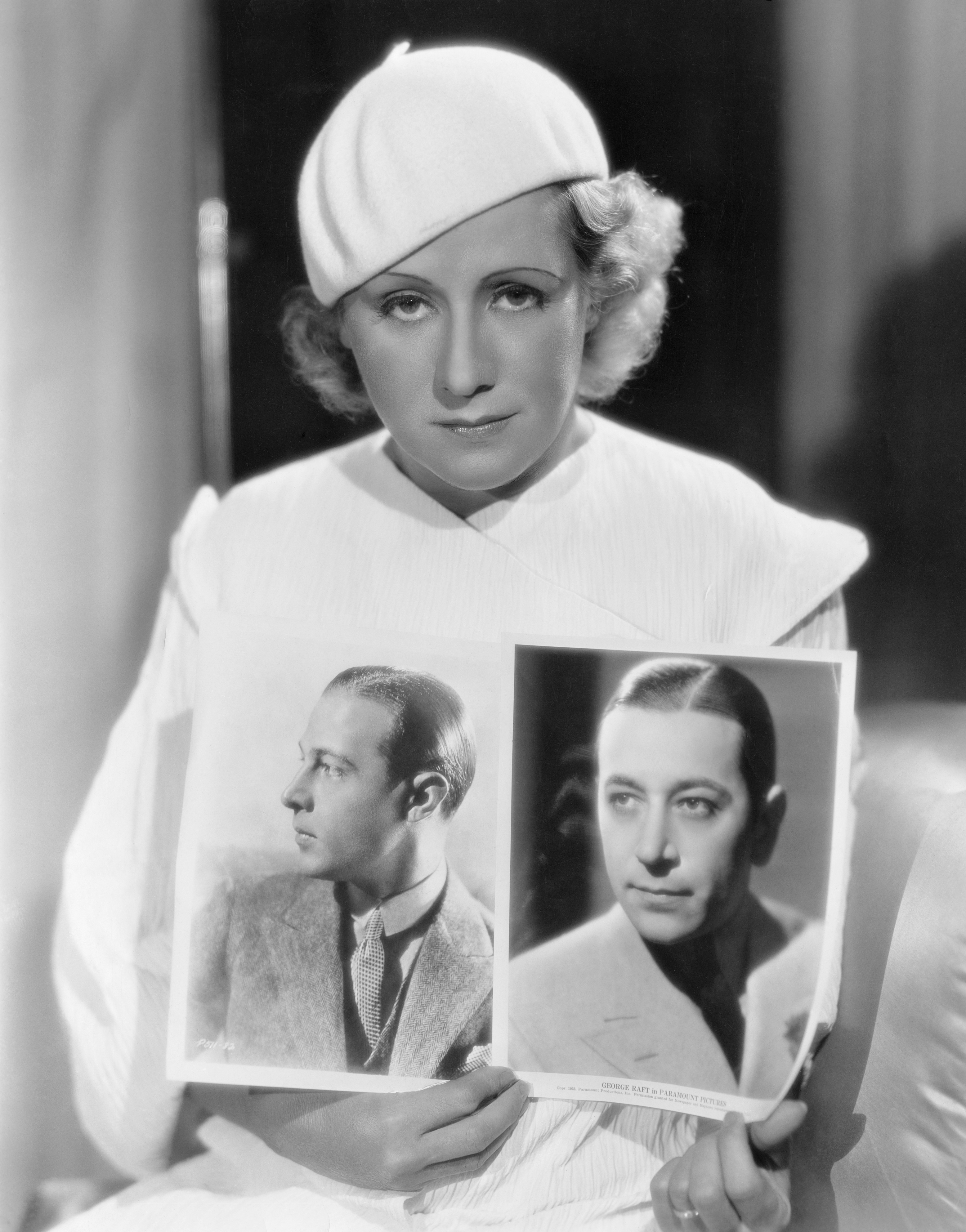 Jean Acker holds up photos of her late ex-husband Rudolph Valentino and George Raft for comparison. (Photo by �� John Springer Collection/CORBIS/Corbis via Getty Images)