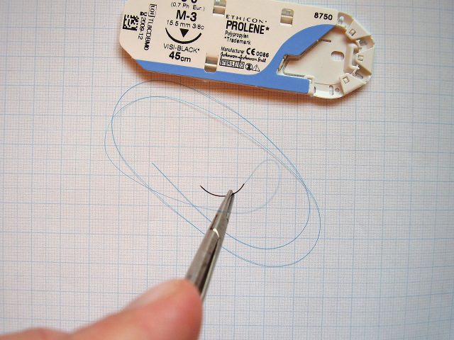 Surgical suture on needle holder. Packaging shown above.