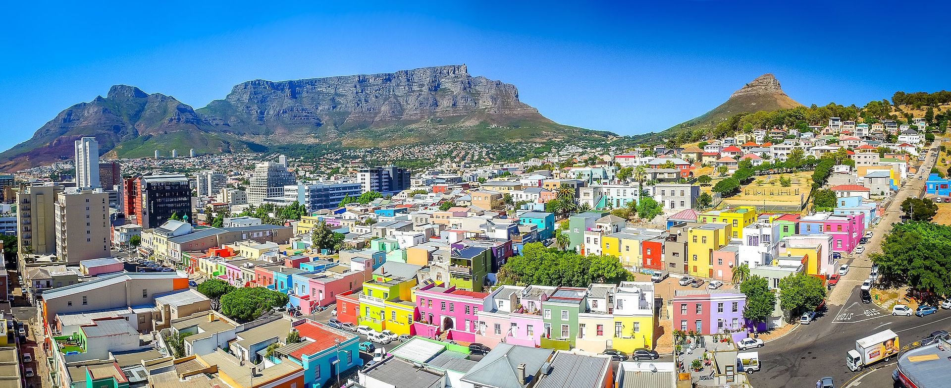 Bo-Kaap area of Cape Town with its distinctive pastel-colored houses in the foreground with the city centre to the left and Table Mountain in the background - Author: SkyPixels - CC BY-SA 4.0