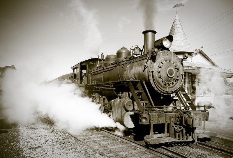 A steam locomotive begins its journey from the station