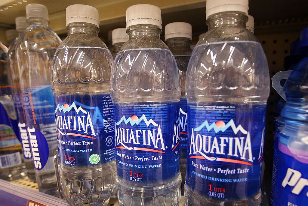 Bottle of Pepsi's Aquafina water sits on a shelf next to other brands of bottled water at a Walgreens store-75817758