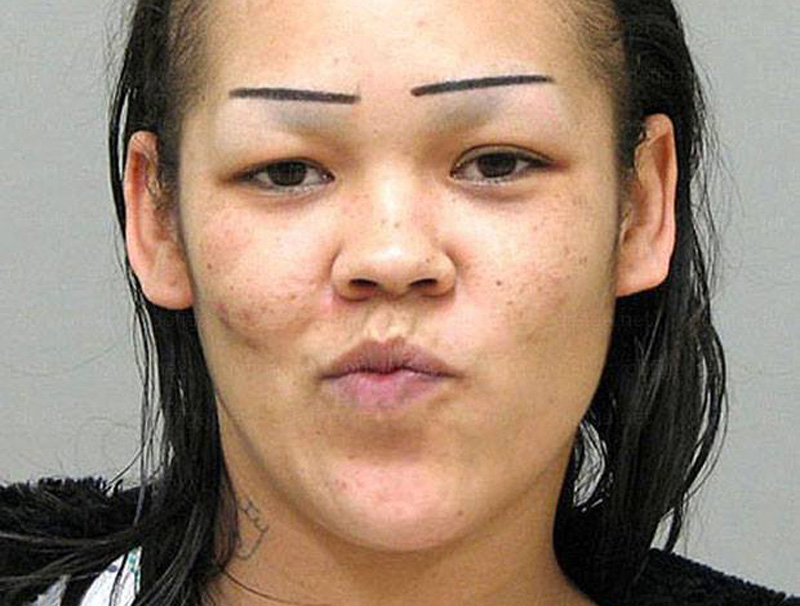 a mugshot of a woman with straight eyebrows