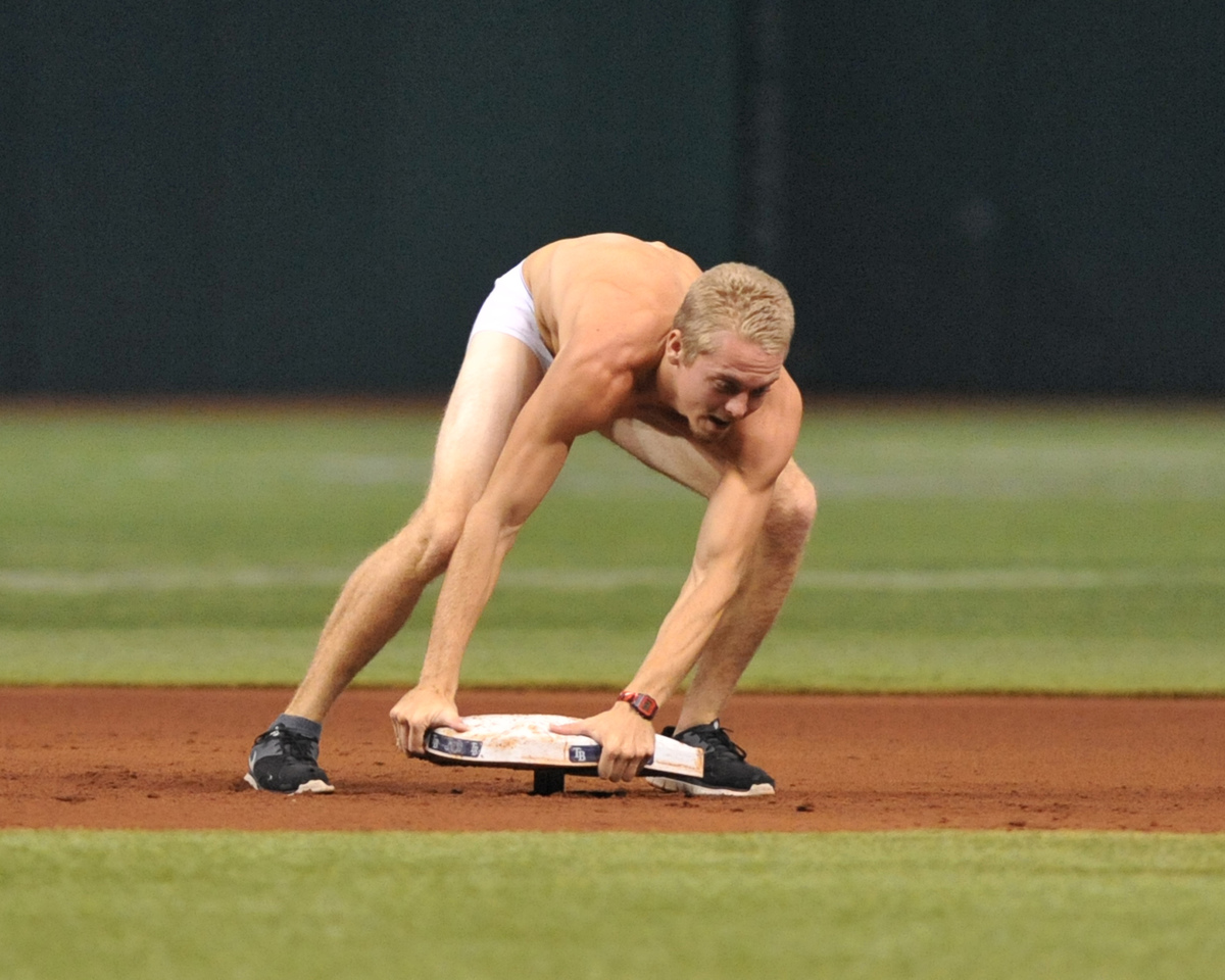 A fan of the Tampa Bay Rays runs to the field and attempts to steal second base during play against the Texas Rangers September 16, 2013 at Tropicana Field in St. Petersburg, Florida.