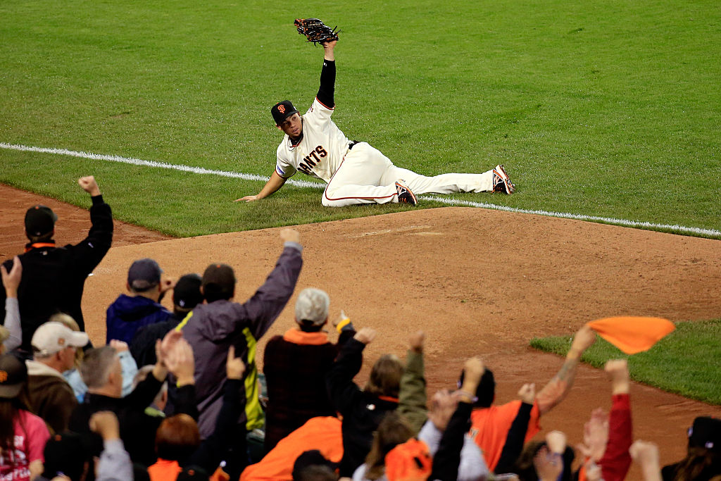 Juan Perez #2 of the San Francisco Giants makes a catch at the foul line on a ball hit by Alex Gordon 