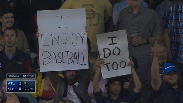 a fan holding a sign that reads i enjoy baseball