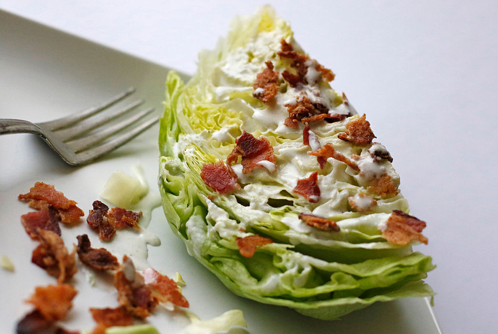 A simple wedge salad sits on a plate