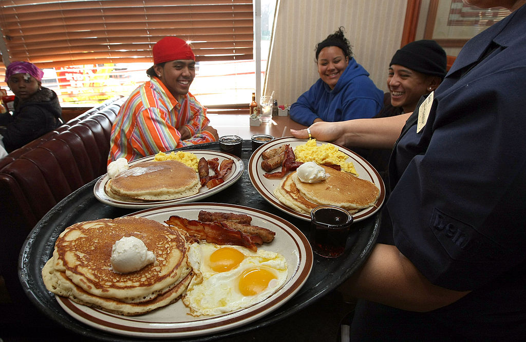 A waitress passes out plates of breakfast