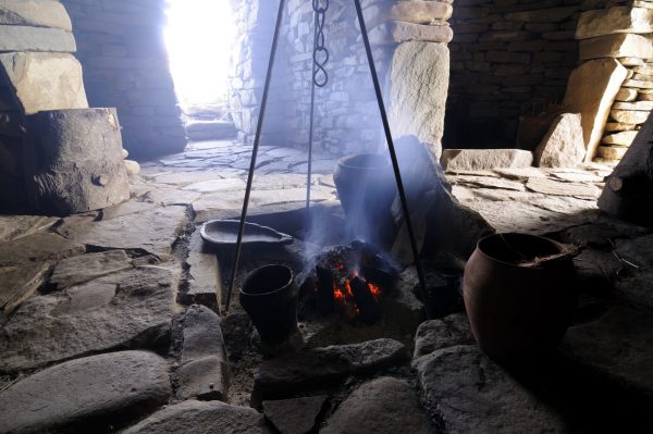 A smouldering peat fire inside a reconstructed iron age house.