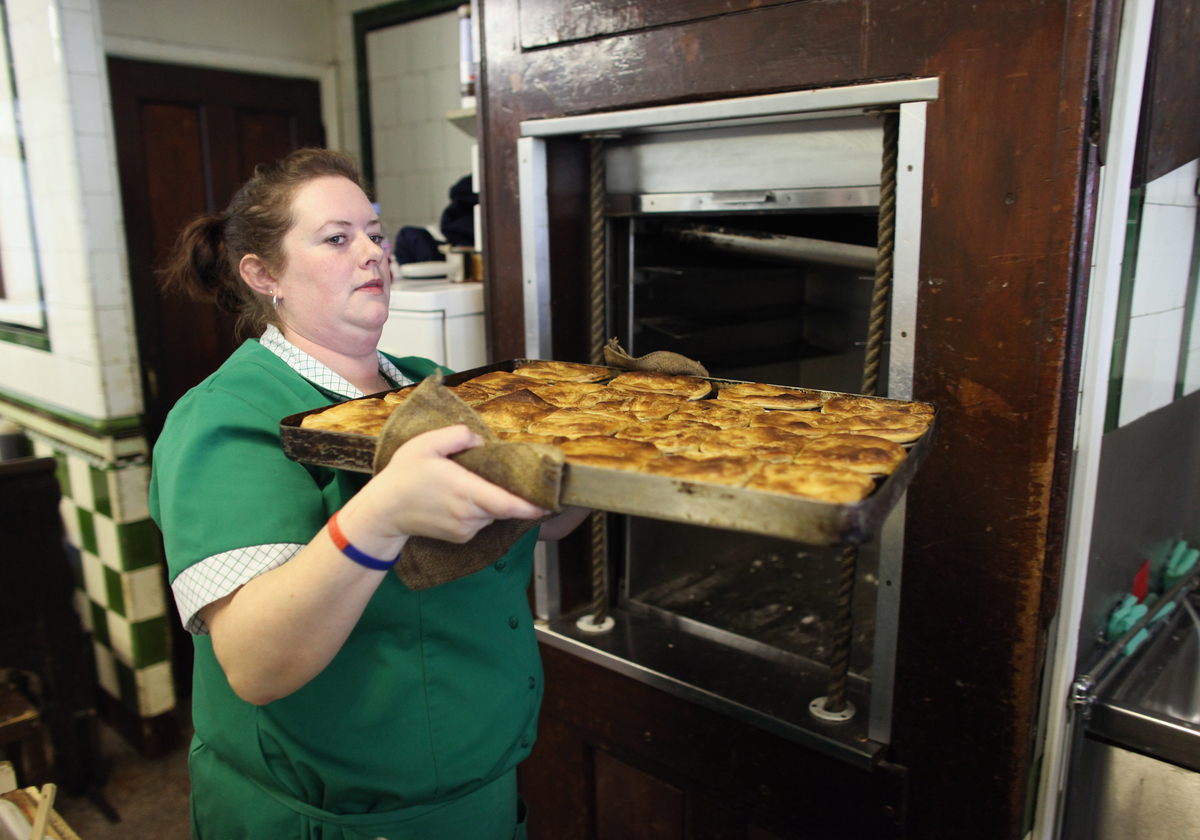 A member of staff removes a tray of freshly cooked pies from the dumbwaiter