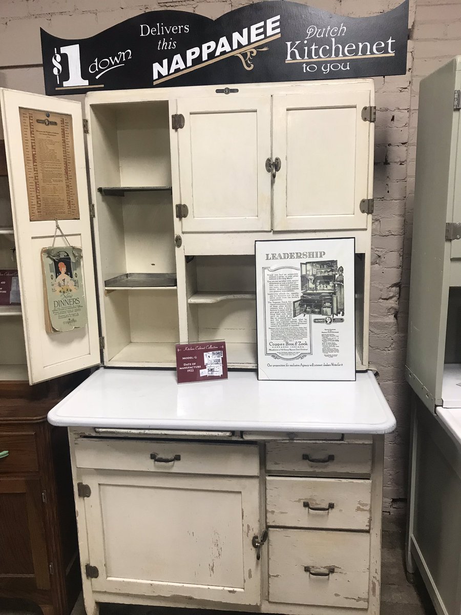 An antique Hoosier desk is decorated with some kitchen decor.