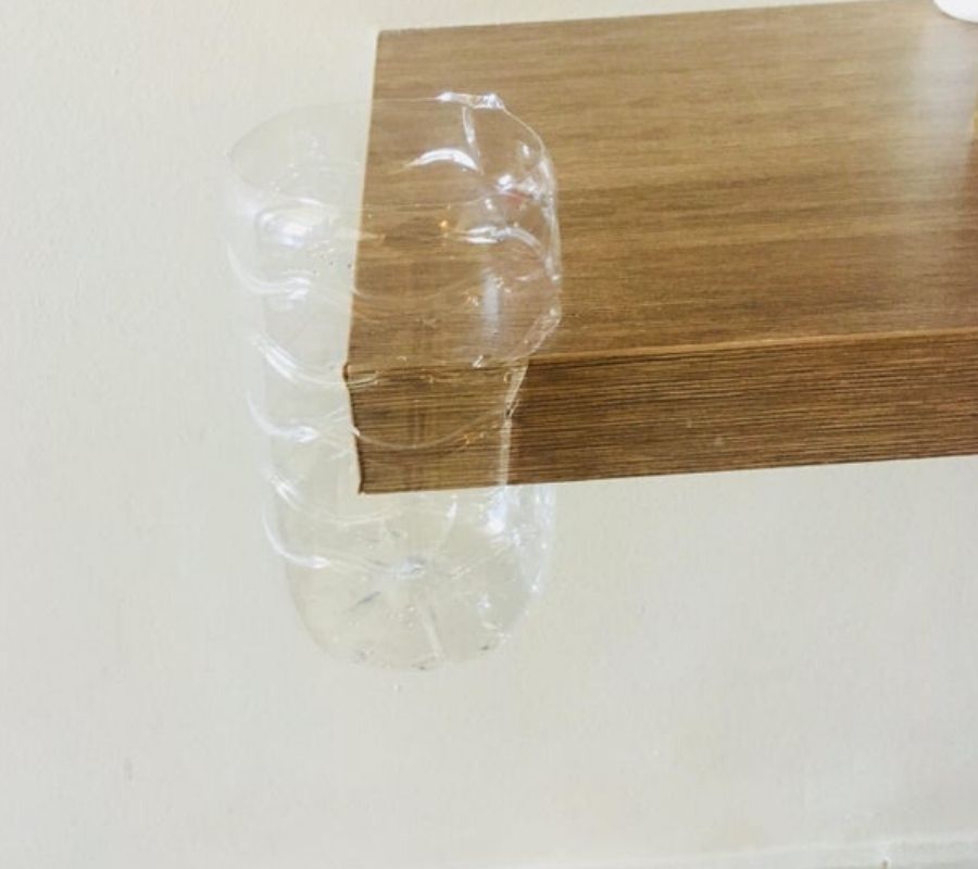 A plastic bottle used to cover a sharp corner