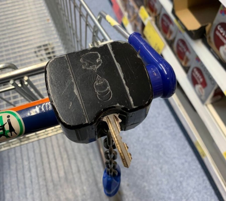 using a key in the coin slot on a grocery cart