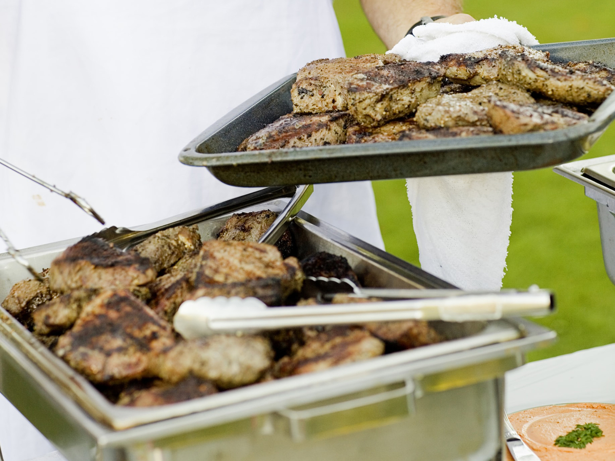 Mean barbecues chicken on the grill.