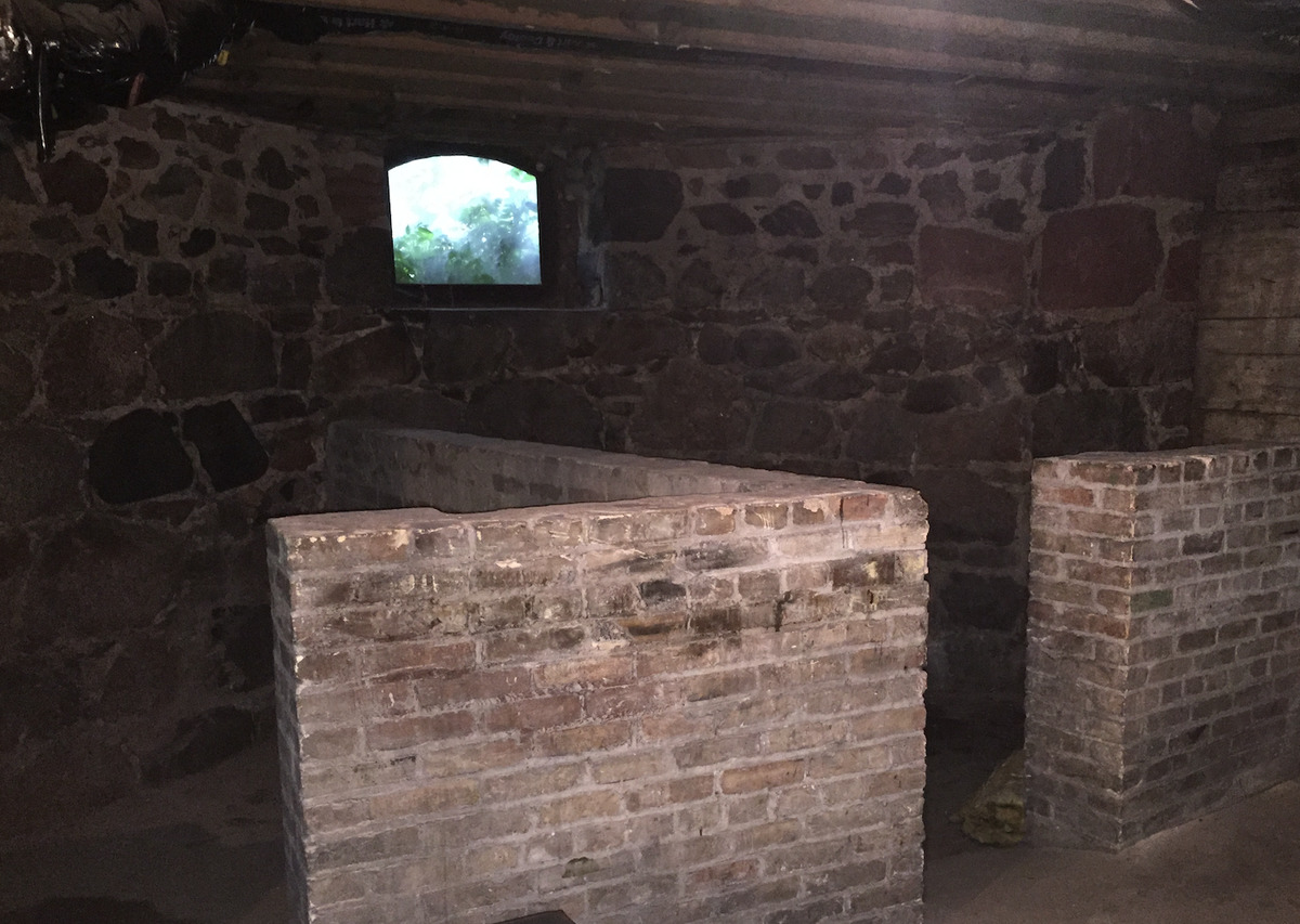 An open coal door leads to a stone basement.