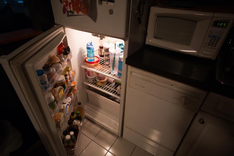 A refrigerator is open at night.