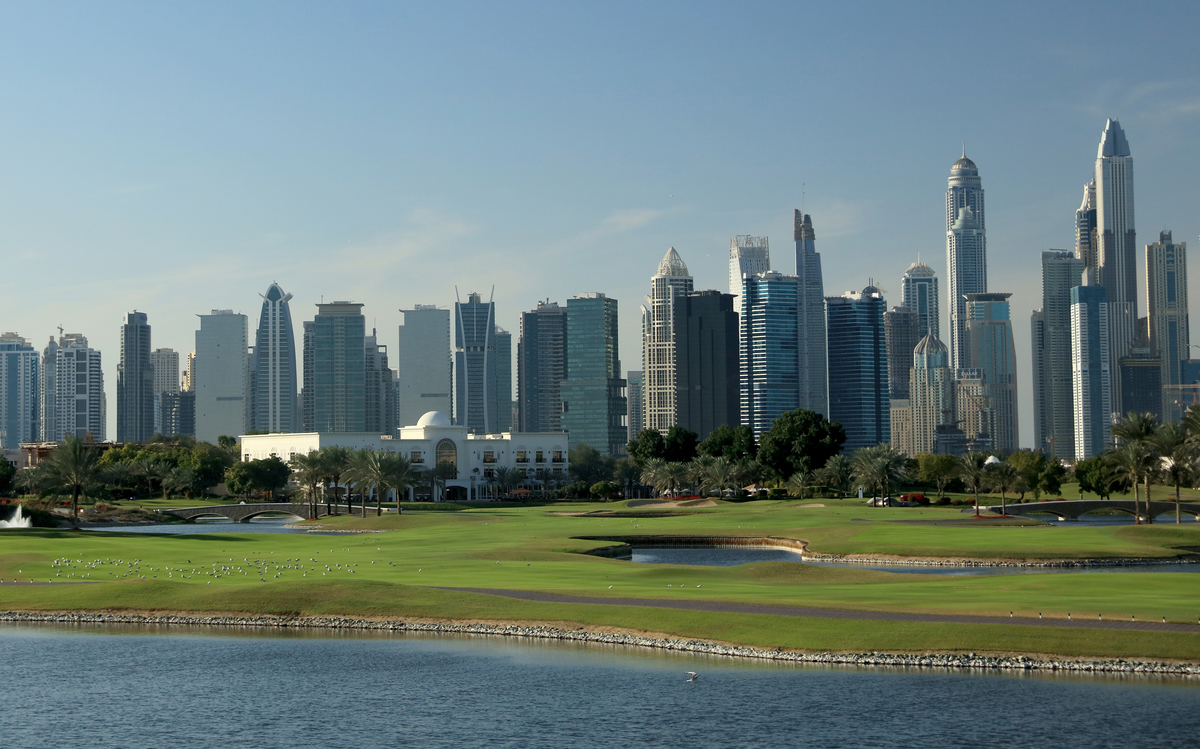 View of the 18th hold at The Adress Montgomerie Golf Club features the city of Dubai in the background.