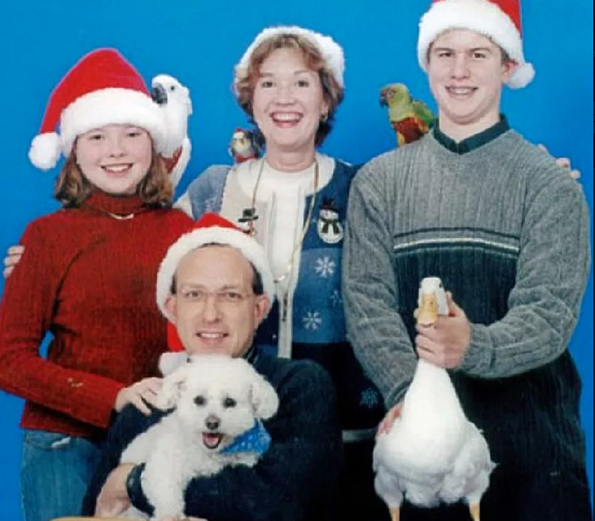 family has many birds ,including a duck, in Christmas photo
