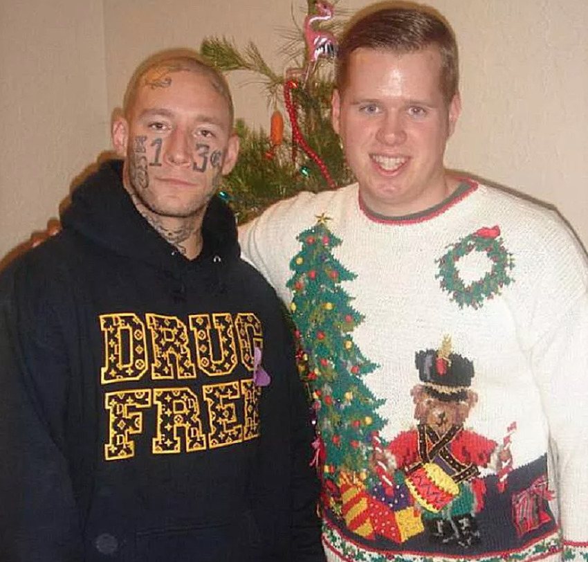 one guy in christmas sweater while other wears hoodie that says 