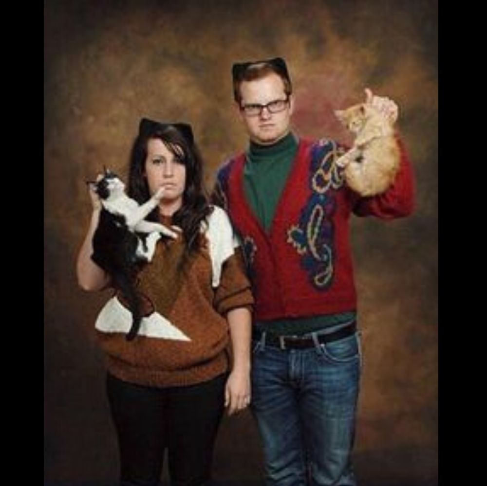 couple hold cats by the neck and look angry