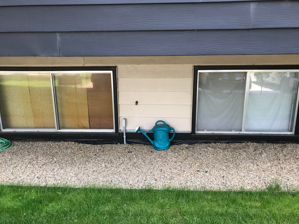 two windows with blinds where one set is yellow thanks to smoking cigarettes