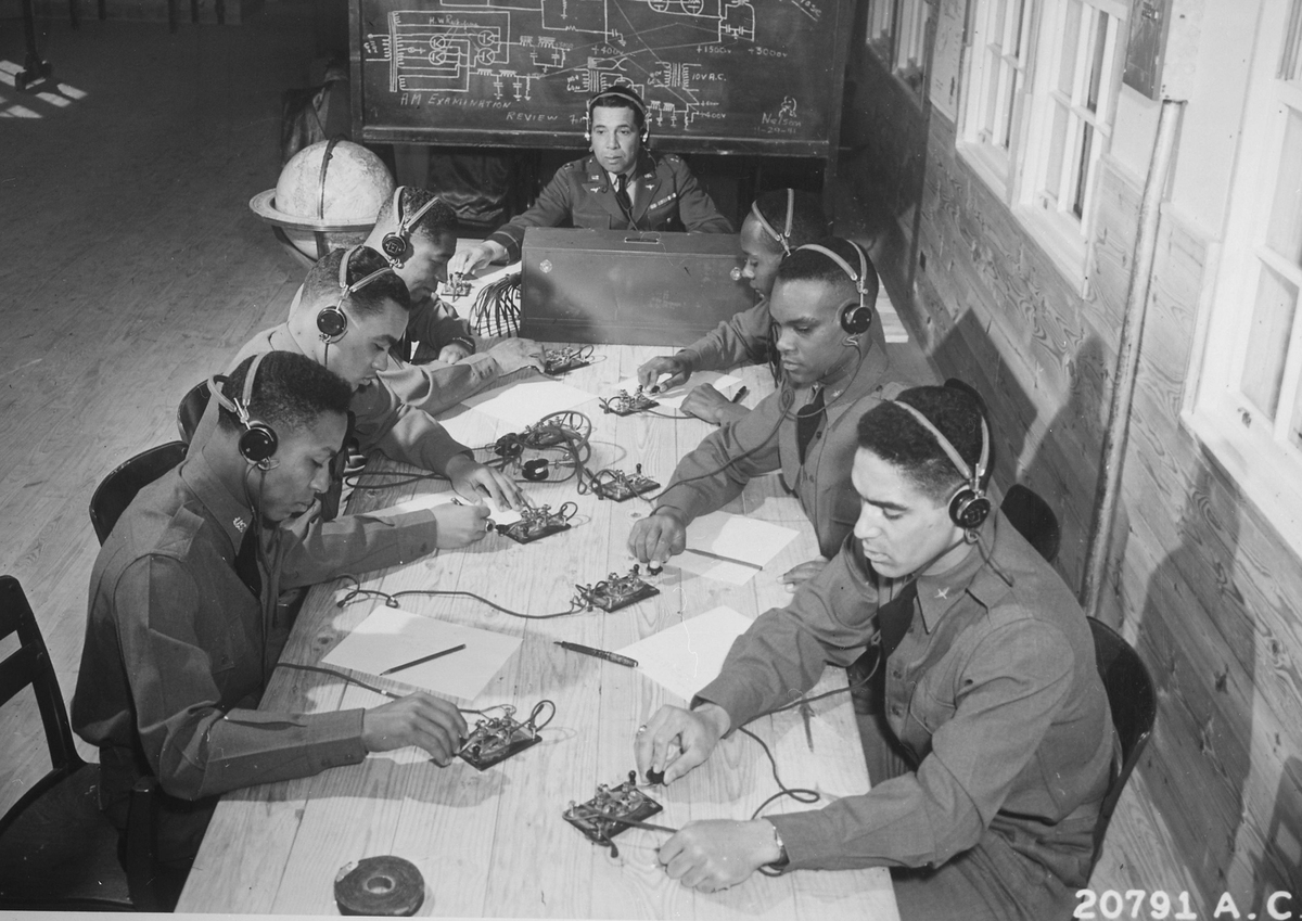 A captain in the Air Corps (center) teaches cadets how to send and receive code during flying school.