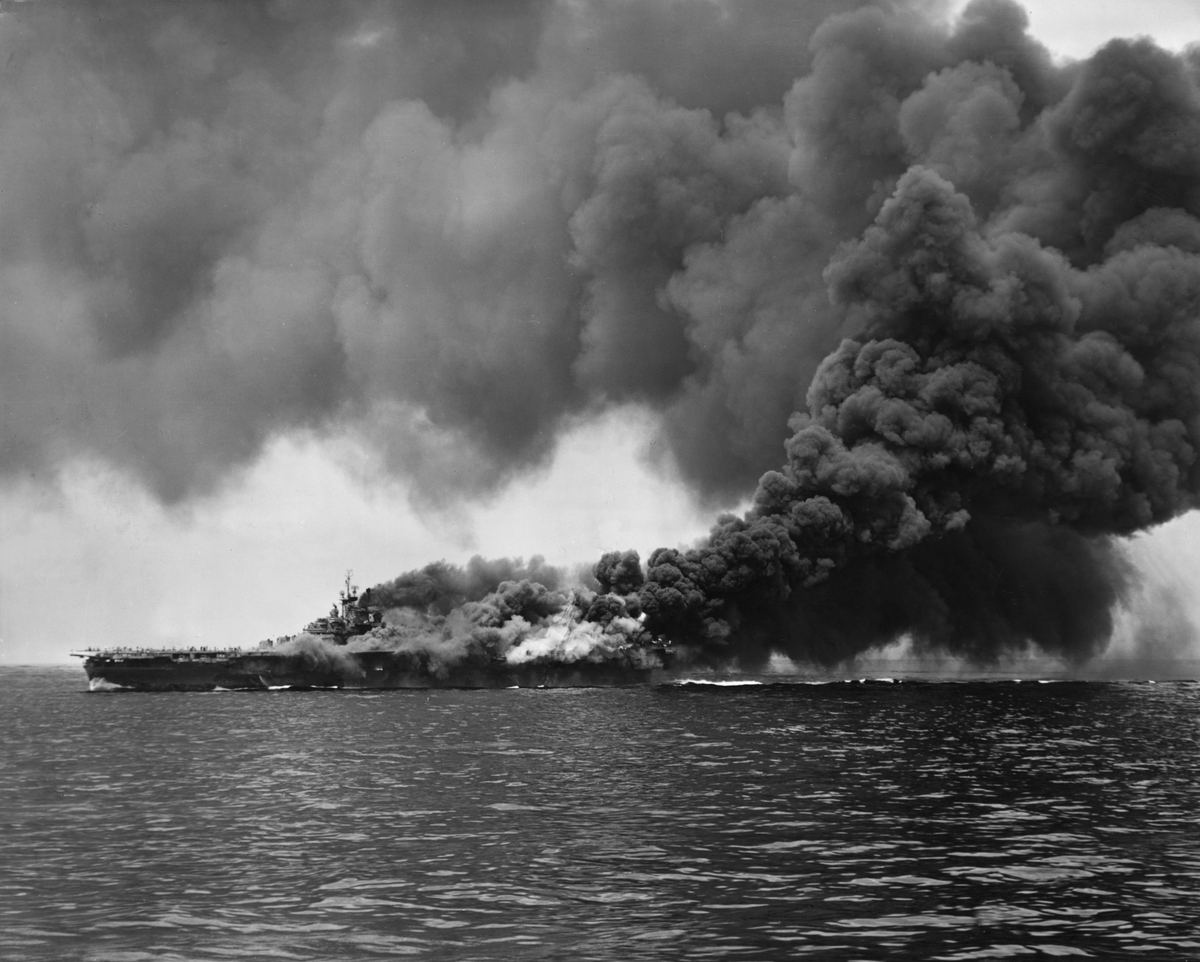 Clouds of black smoke rise from the USS 'Bunker Hill' aircraft carrier after it was hit twice by Japanese Kamikaze planes during World War II.