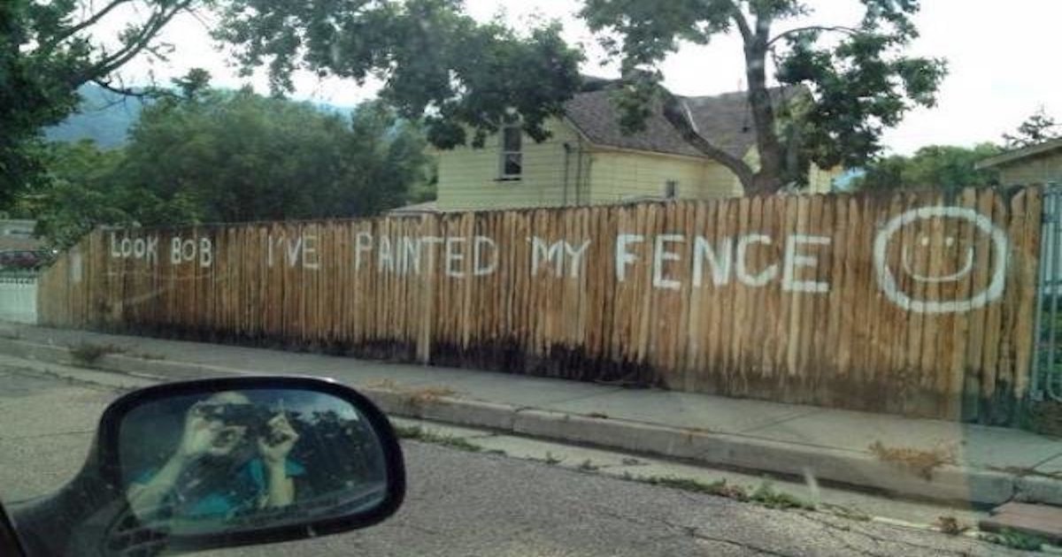 An old fence is painted with the words 