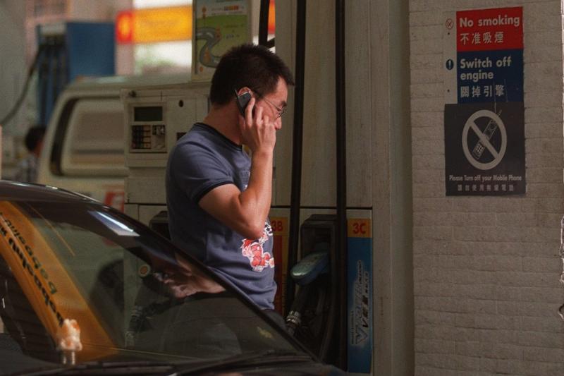 Man on the phone at a gas station