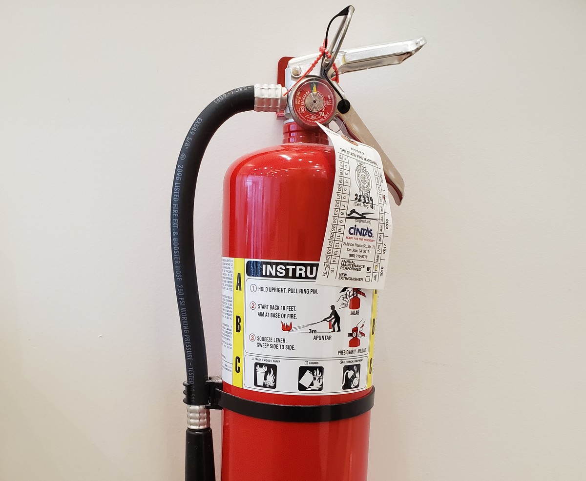A fire extinguisher is mounted to a wall.