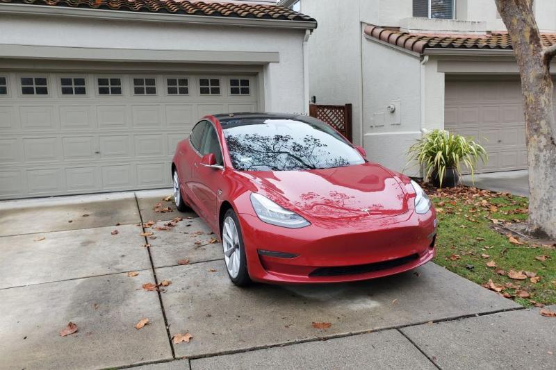 A car is parked backwards in a driveway.