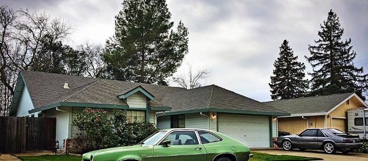 Green car in front of house