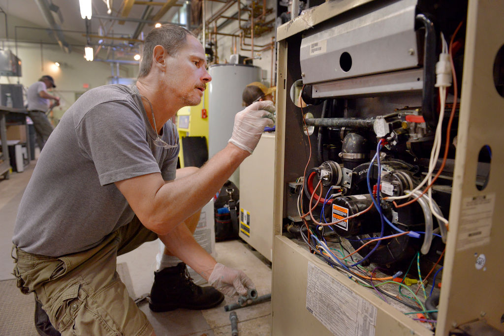 Steven Sweet, from Windham, works on a gas furnace