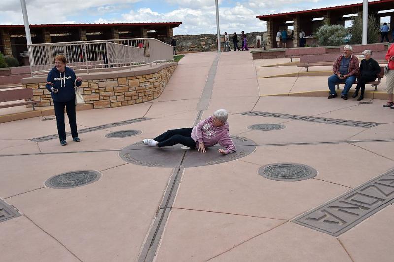 an old lady laying down on the ground of the four corners monument