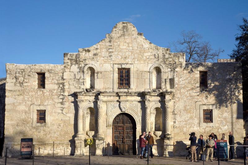 tourists posing for photos outside the alamo