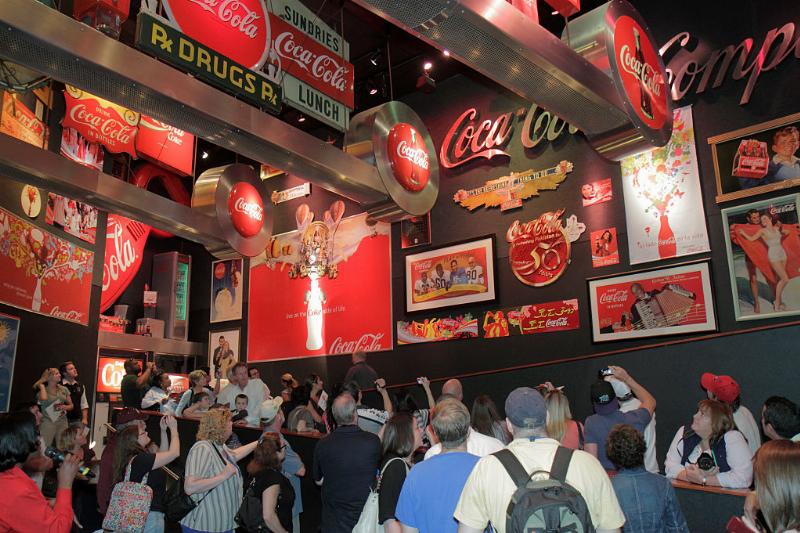 tourists taking photos of advertisements at the world of coca-cola