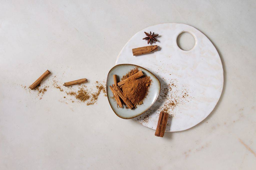 a plate with cinnamon sticks and powder