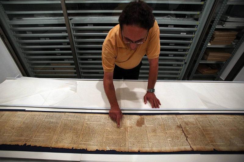 Man examining the Dead Sea Scroll 