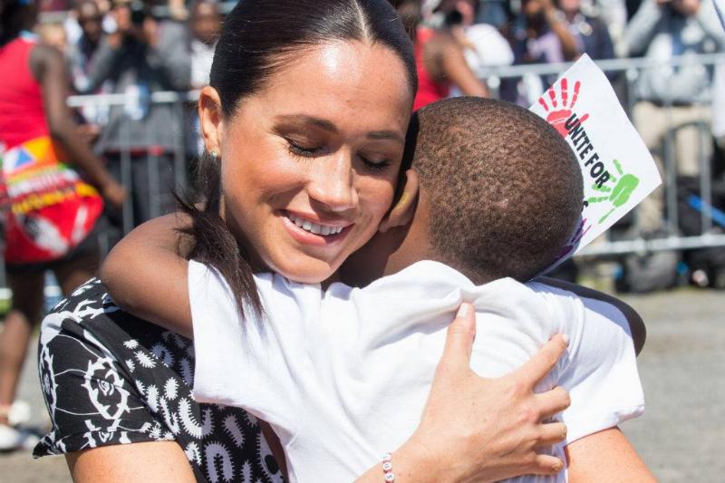 Meghan-hugs-child-1176960486-73864